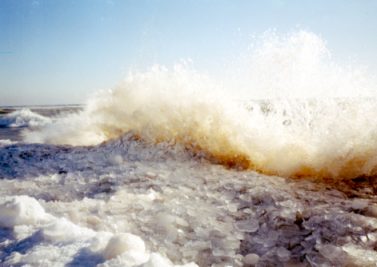 Wave crashing on ice bank